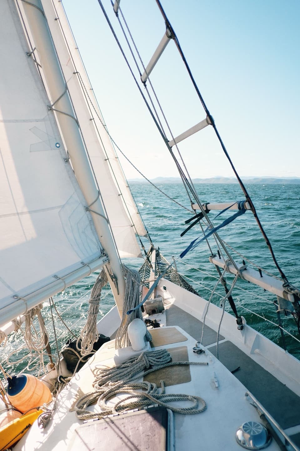 Proa de un velero navegando, con cabos y la vela de proa